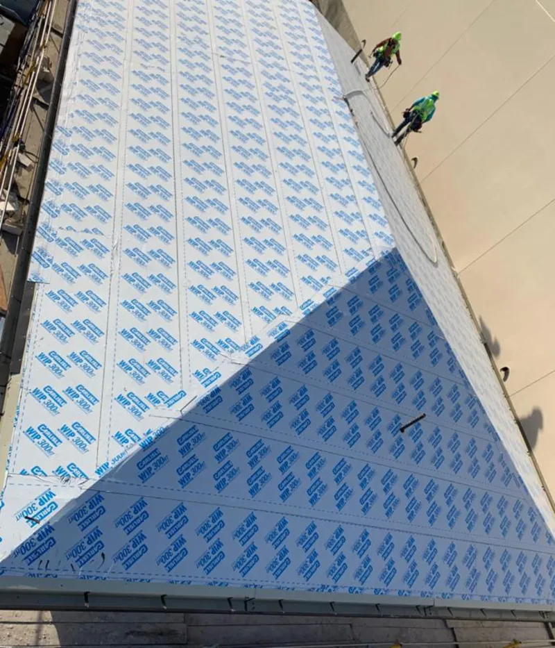 Professional roofers installing underlayment on a metal roof in Port Jervis